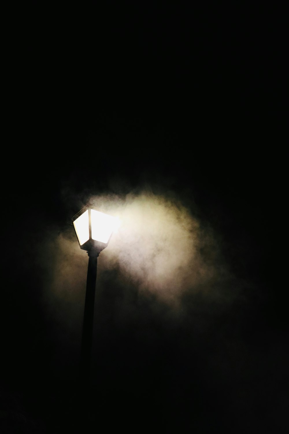 a street light with smoke coming out of it