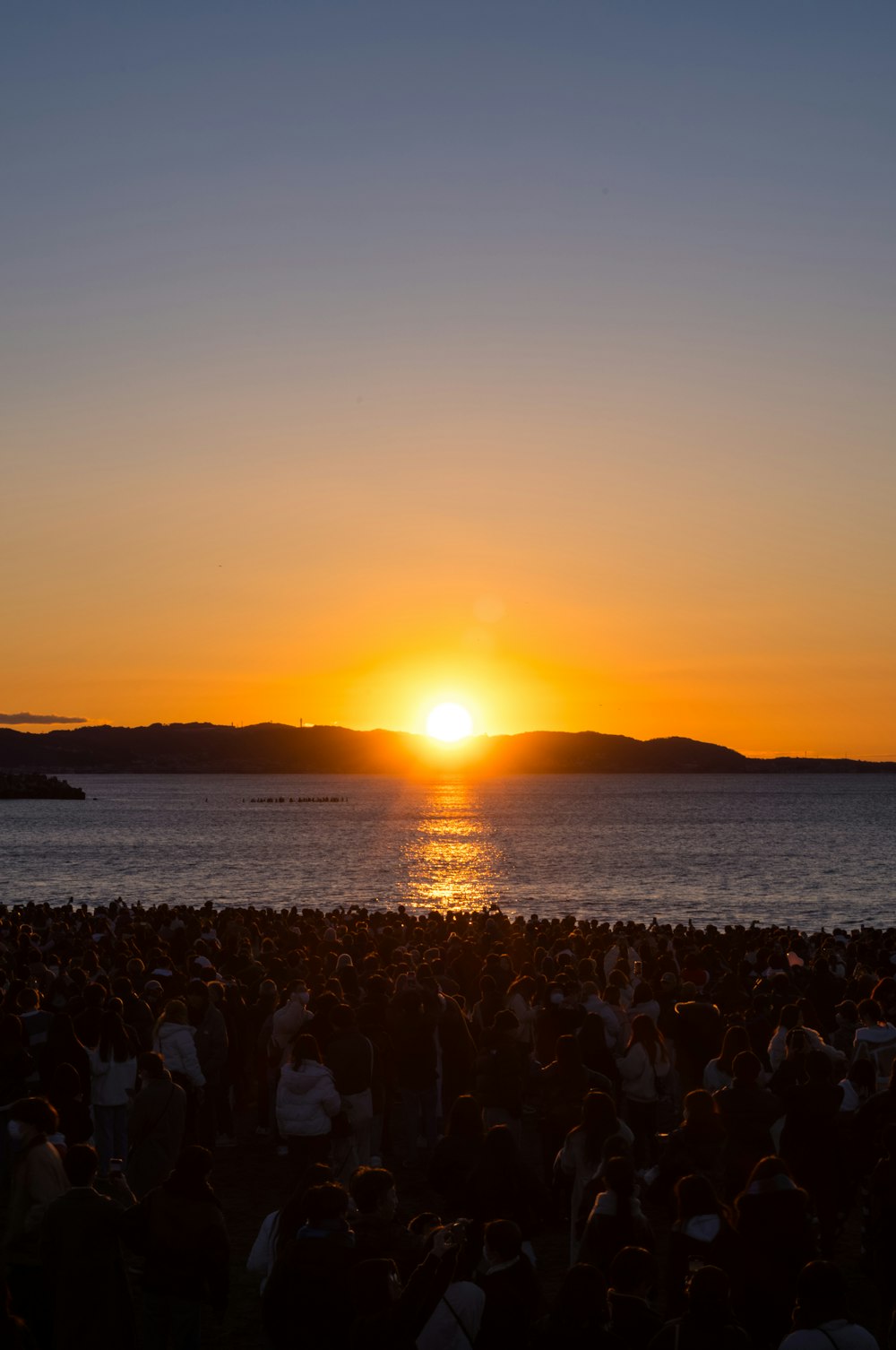 a group of people standing on top of a beach