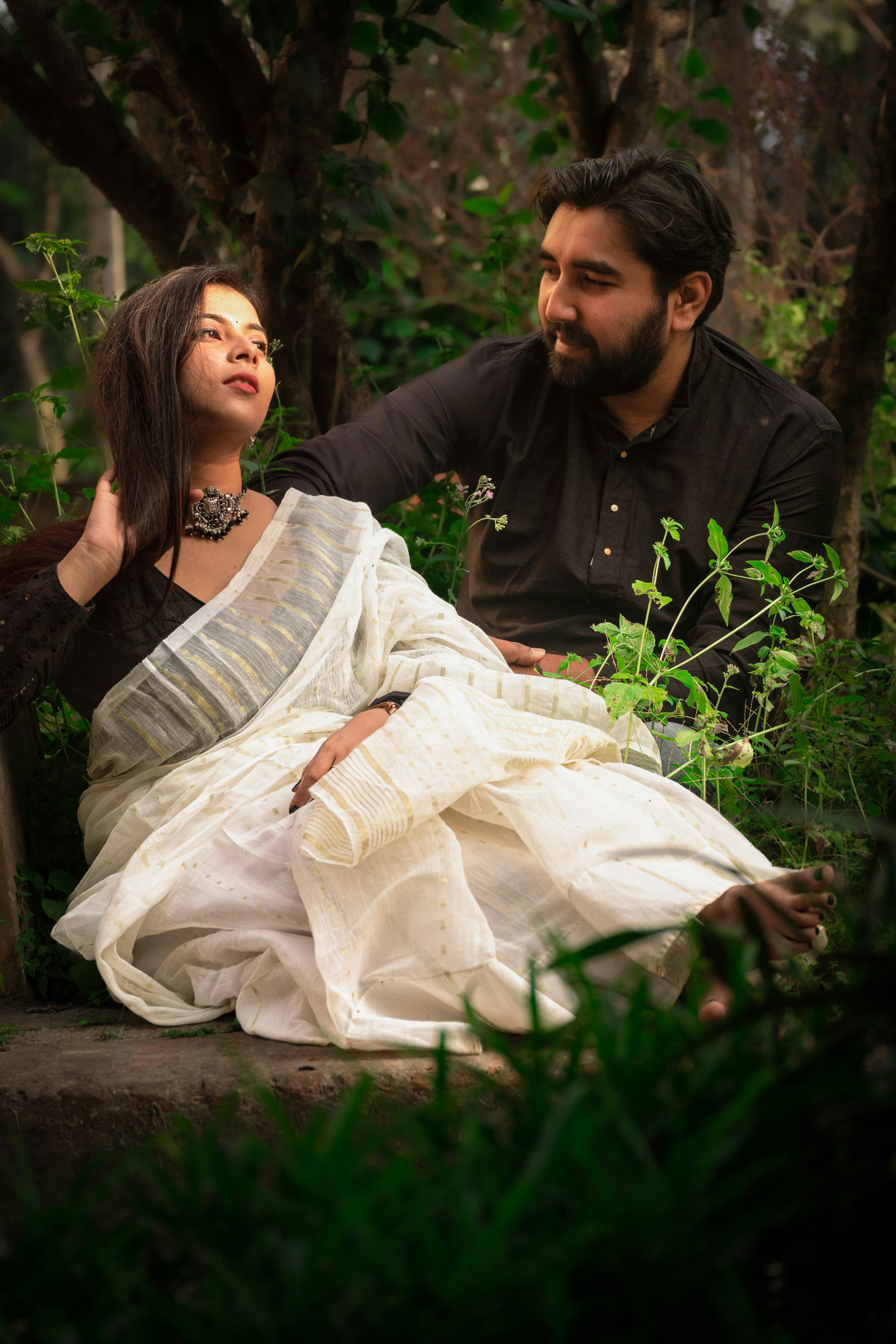 un homme assis à côté d’une femme en robe blanche