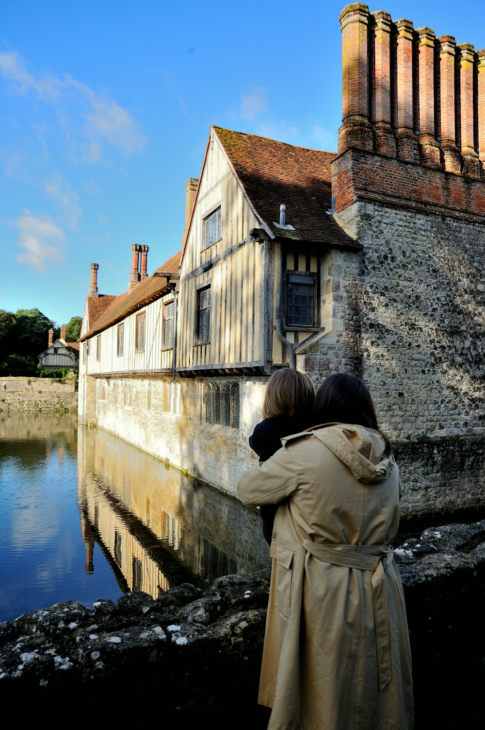 a woman standing next to a body of water