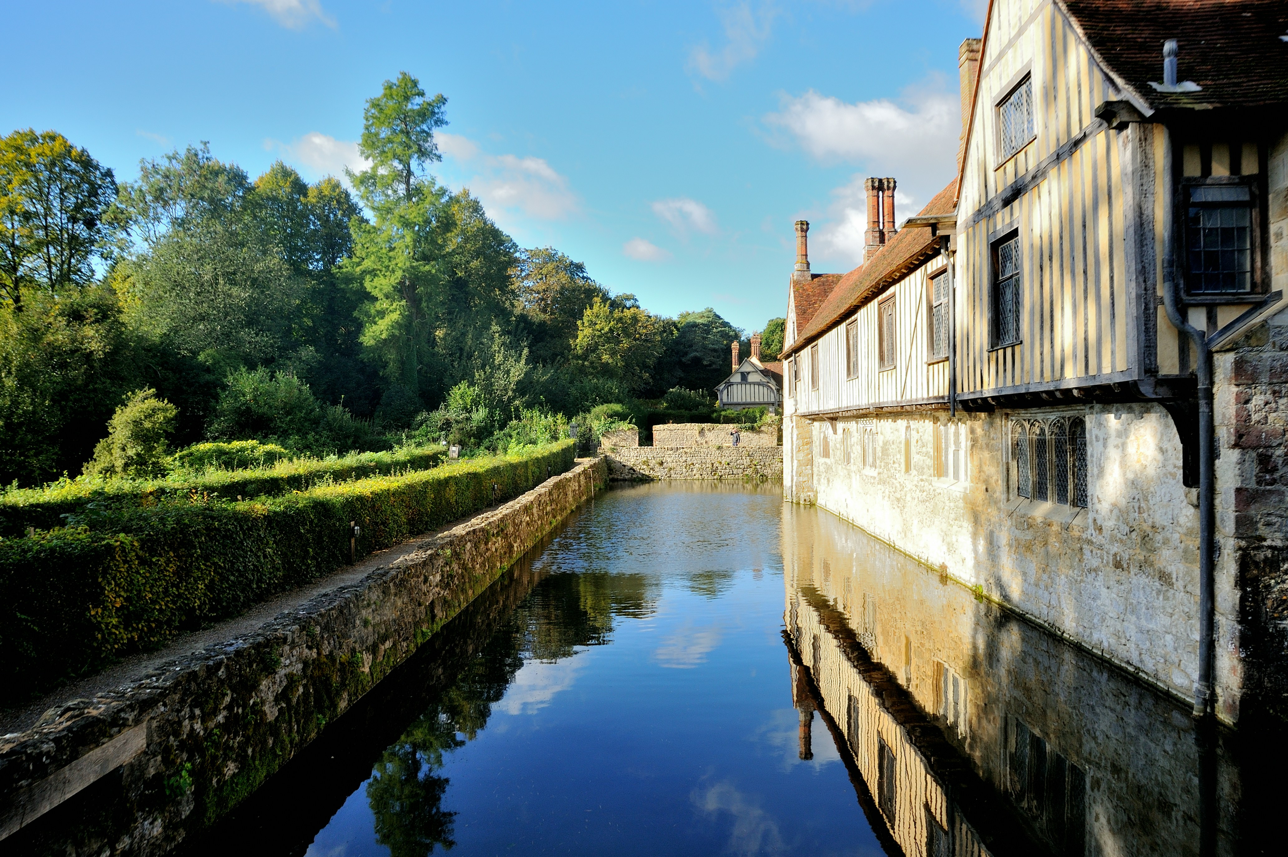 a river running between two buildings next to a forest