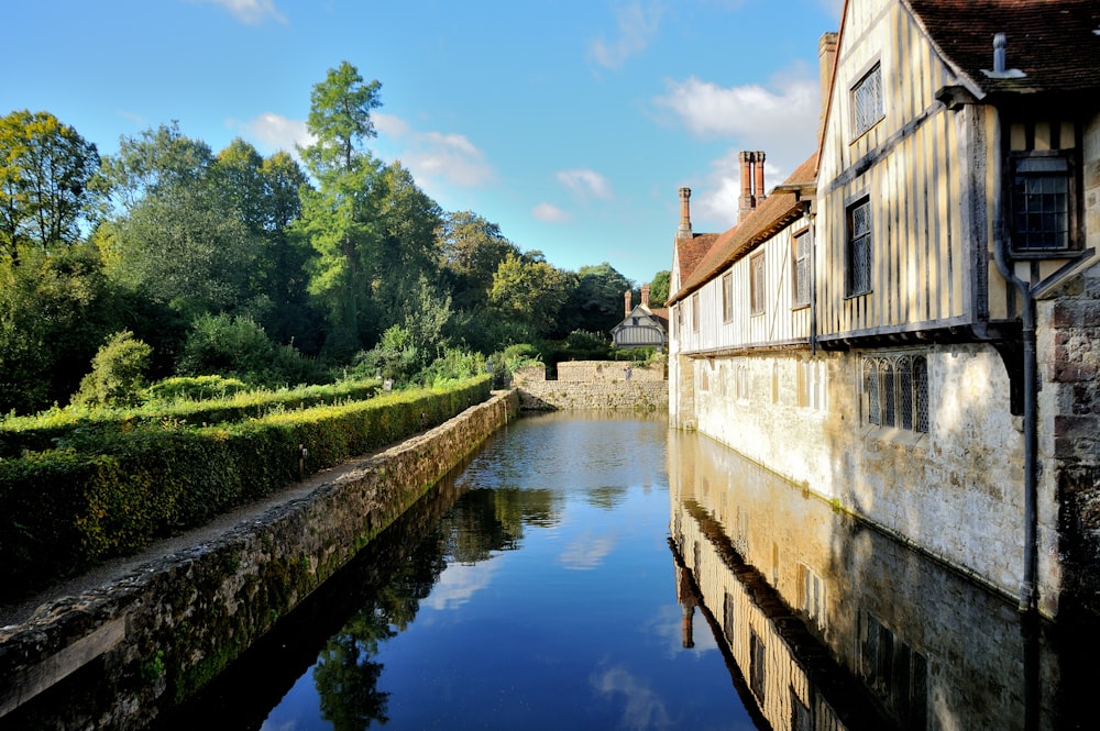 a river running between two buildings next to a forest