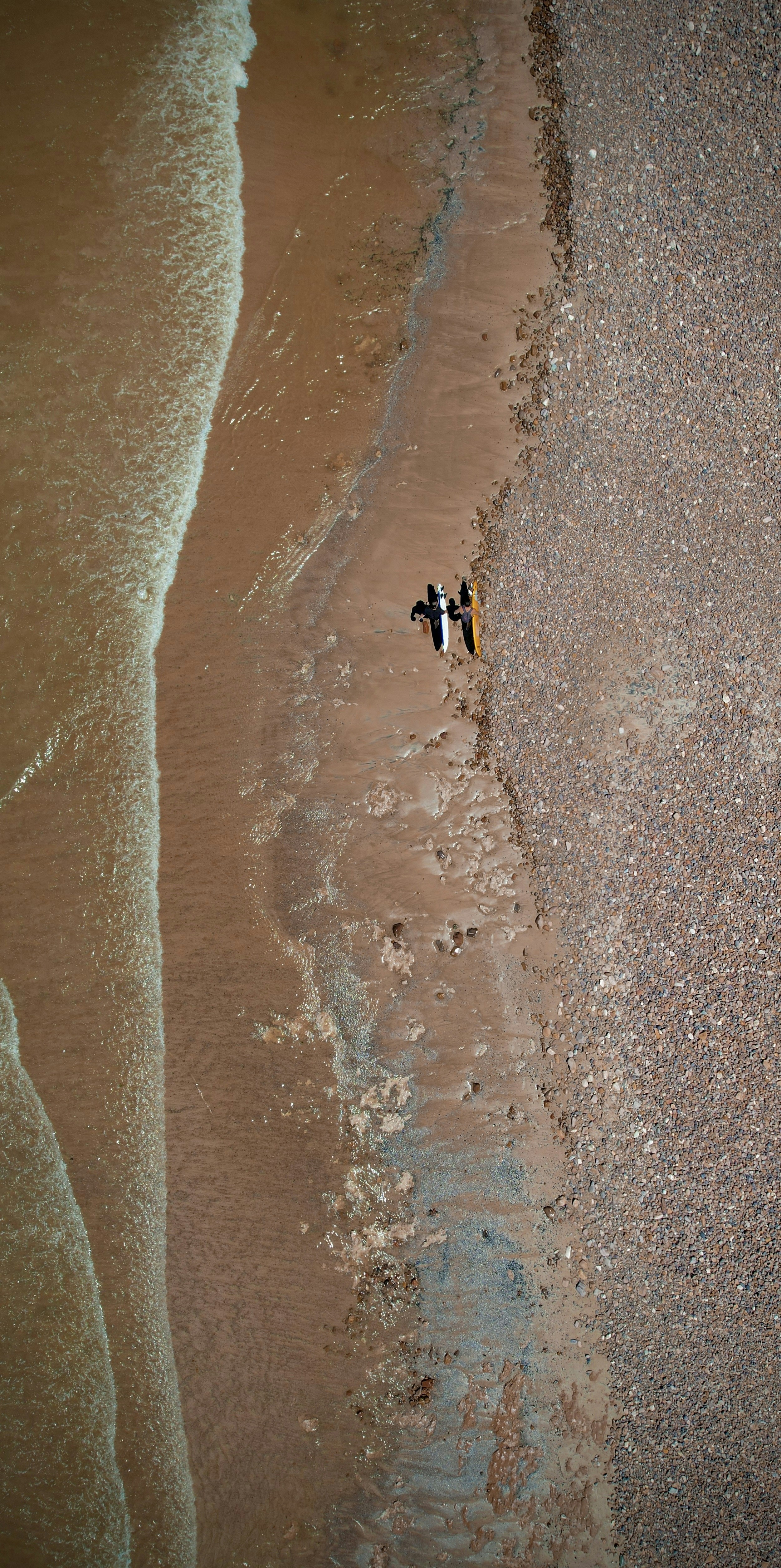 Un par de personas caminando por una playa junto al océano
