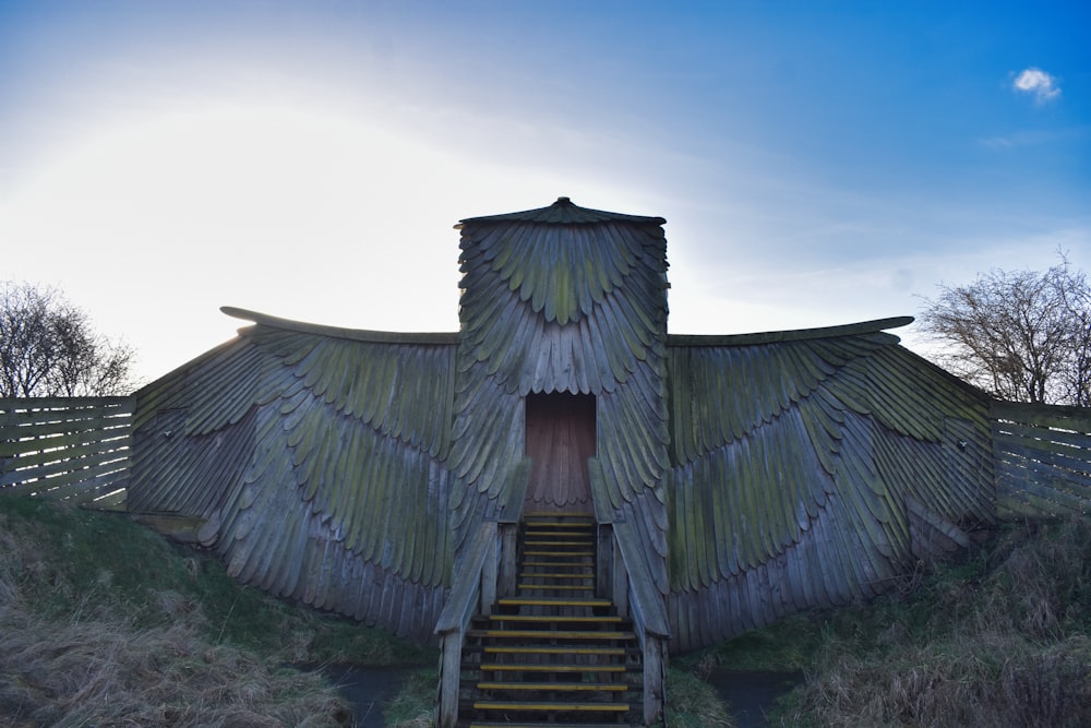 a wooden structure with a large bird wing on top of it