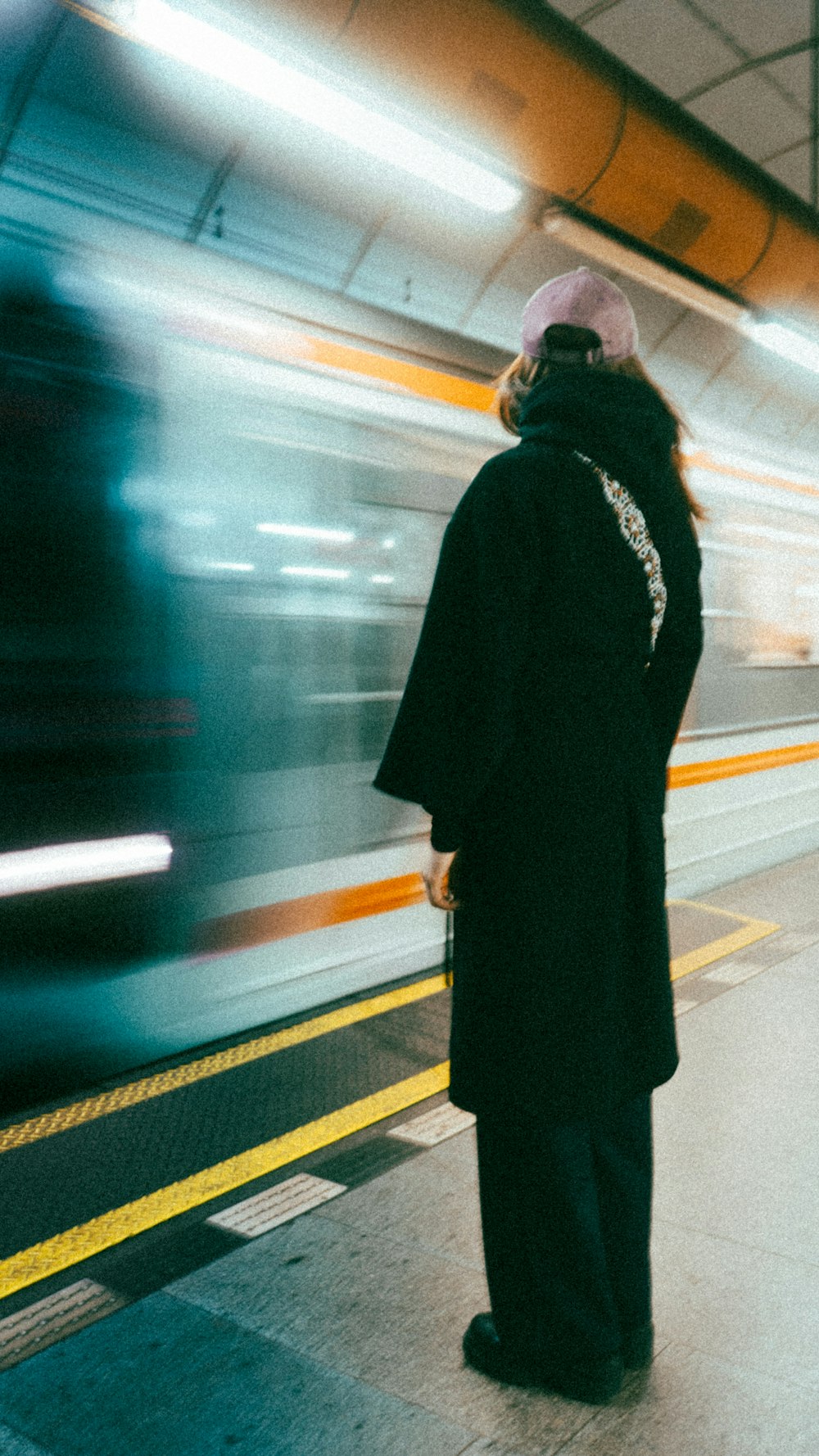 a woman waiting for a train at a train station