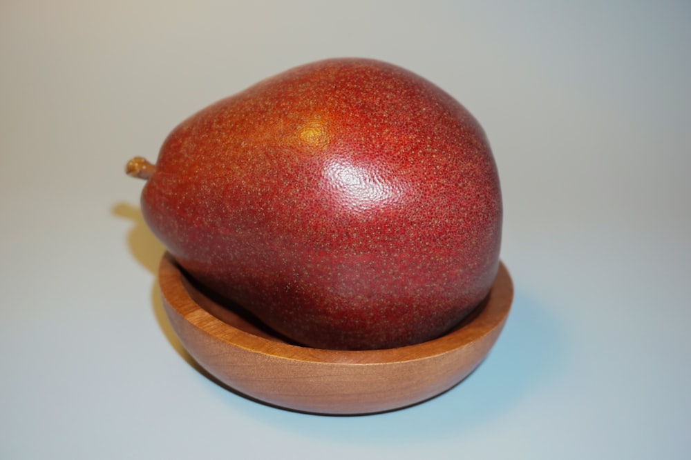 a close up of a pomegranate in a wooden bowl