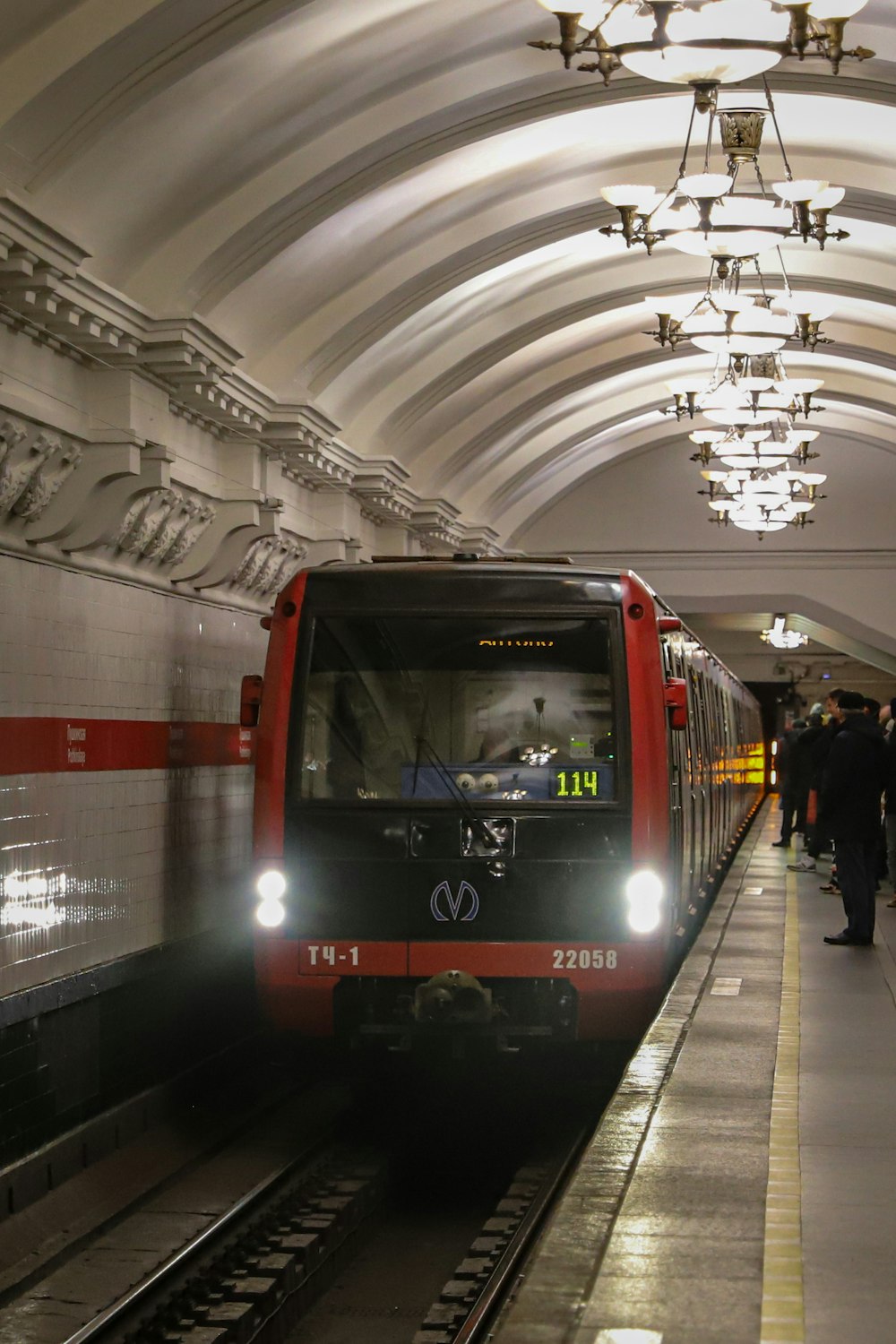 a red train pulling into a train station