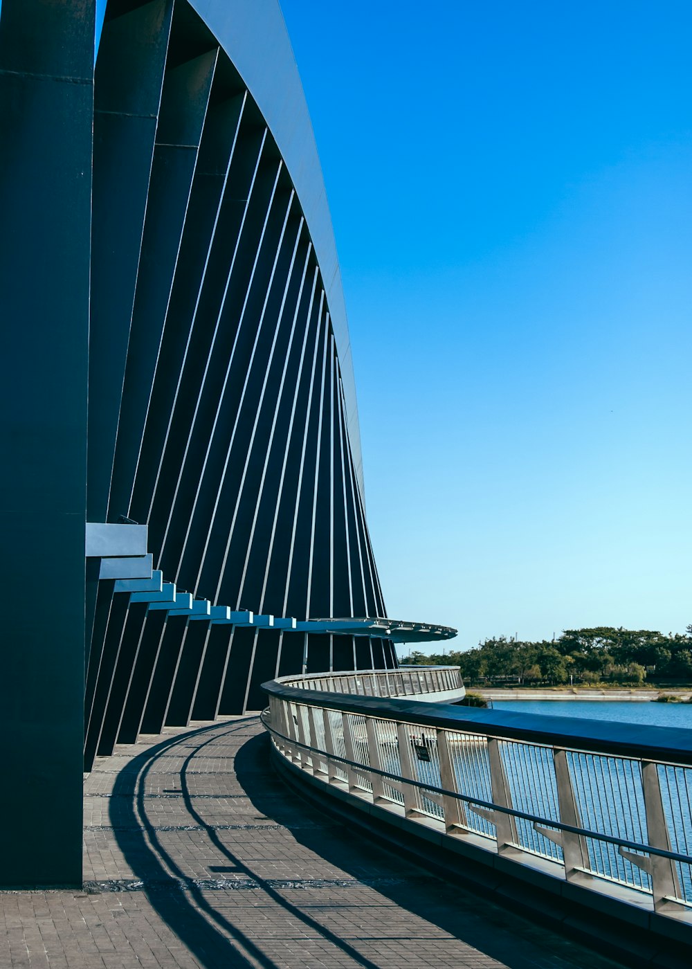 a curved walkway next to a body of water