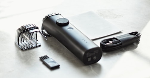 a close up of a hair dryer and comb on a table