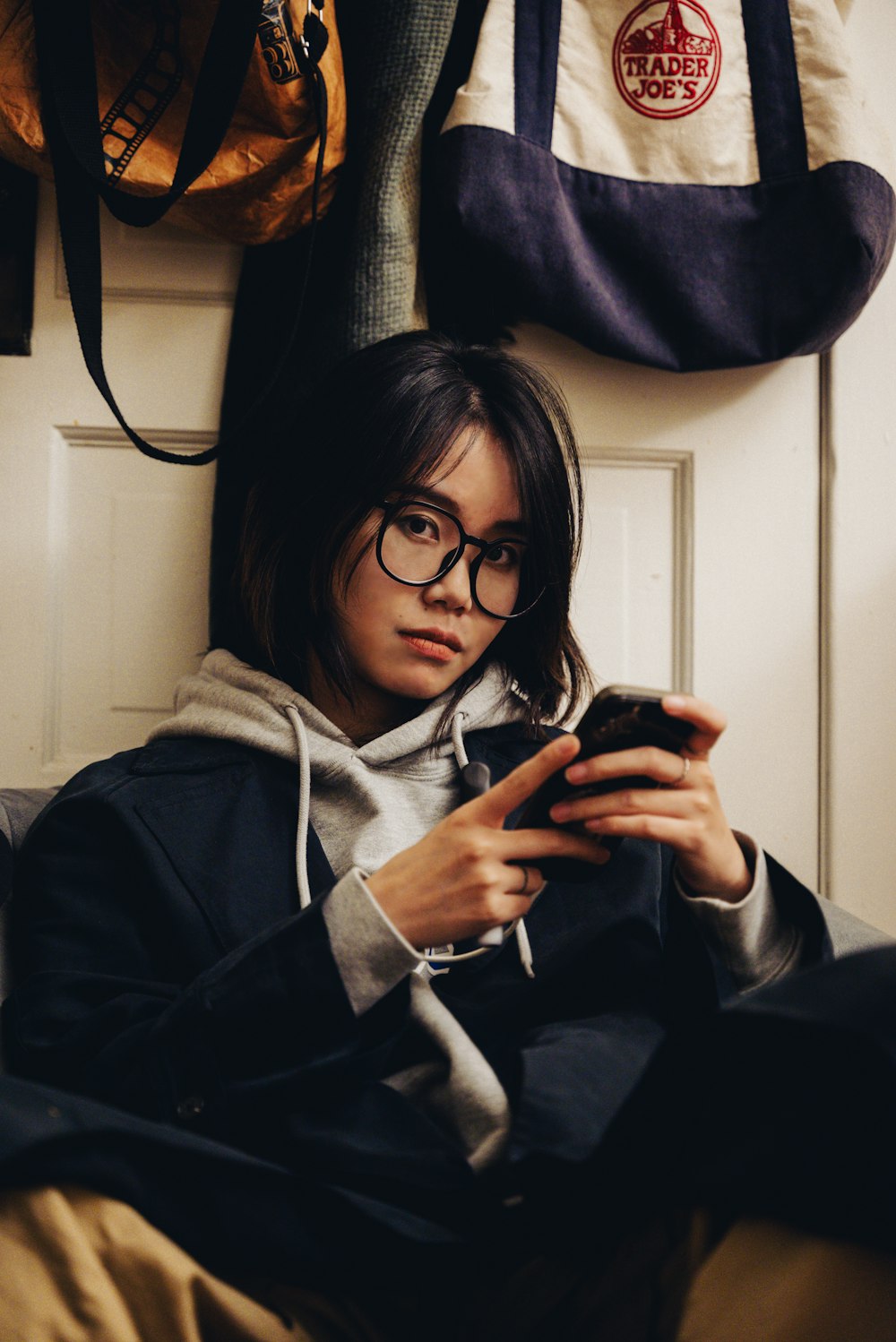 a woman sitting on a couch looking at her cell phone