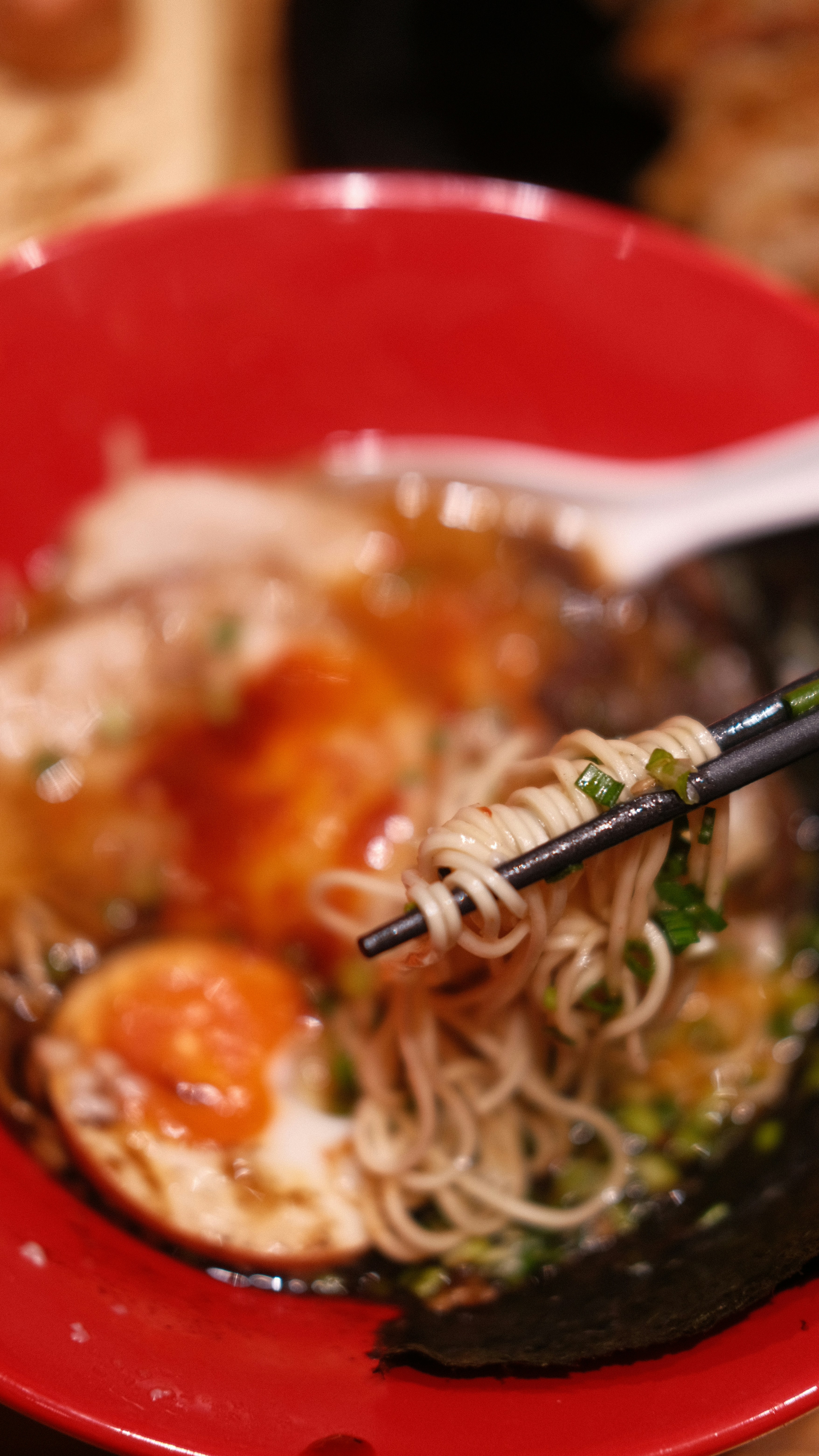 a red bowl filled with noodles and meat