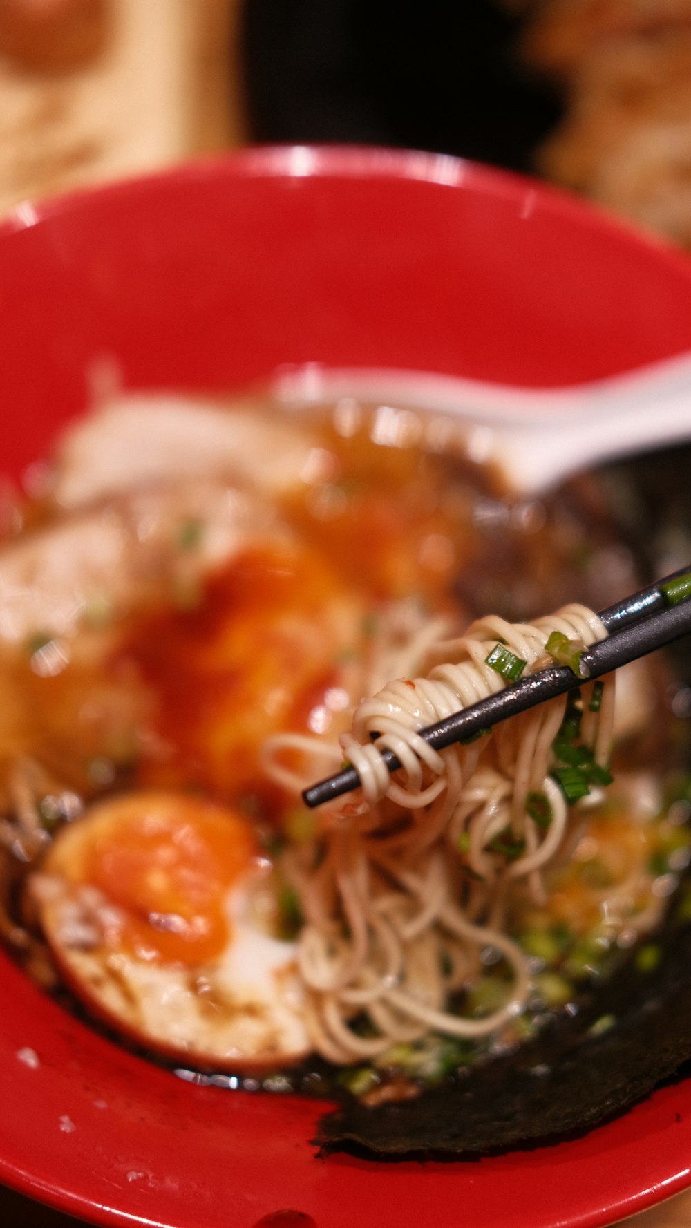 a red bowl filled with noodles and meat