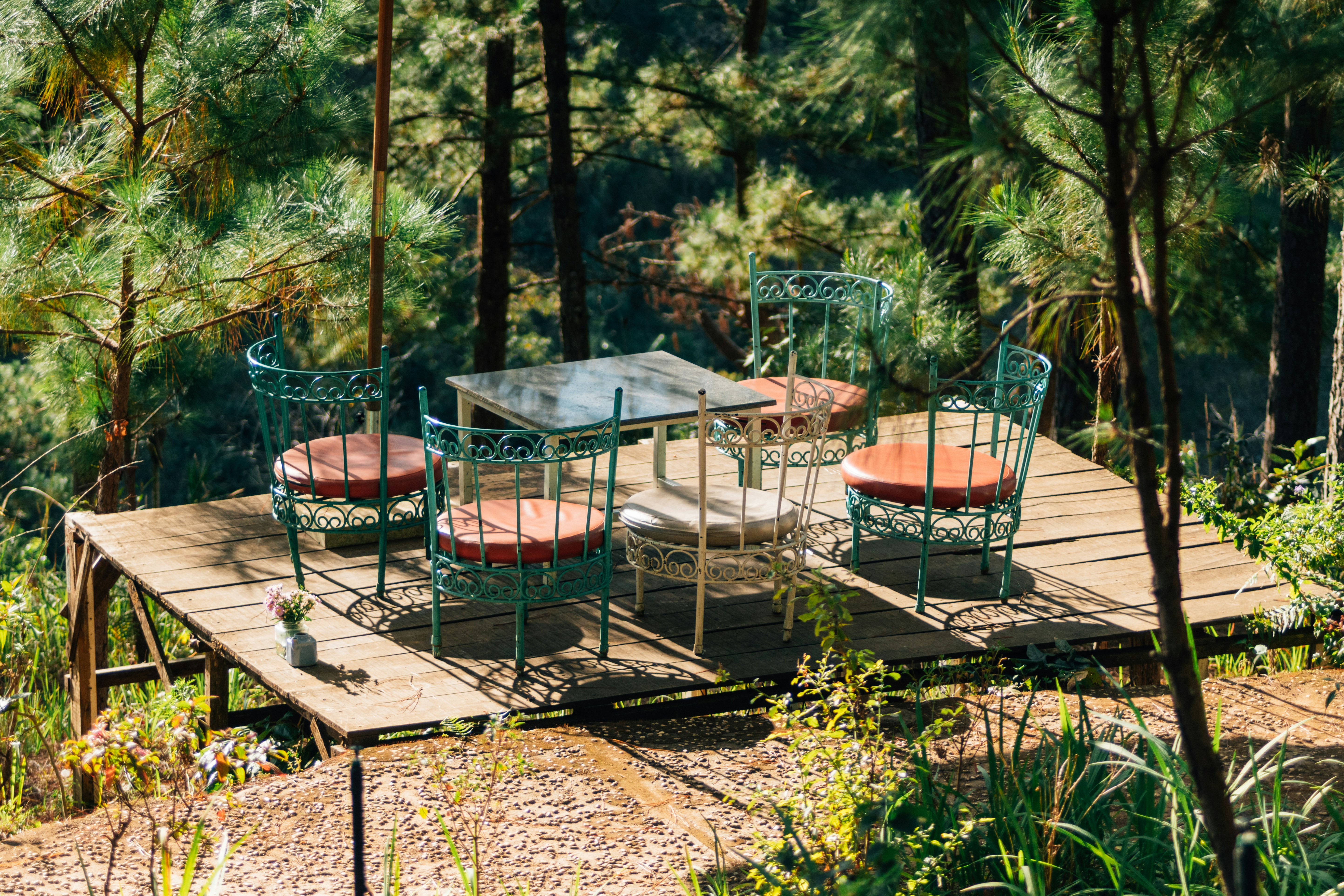 une table et des chaises sur une plate-forme en bois dans les bois