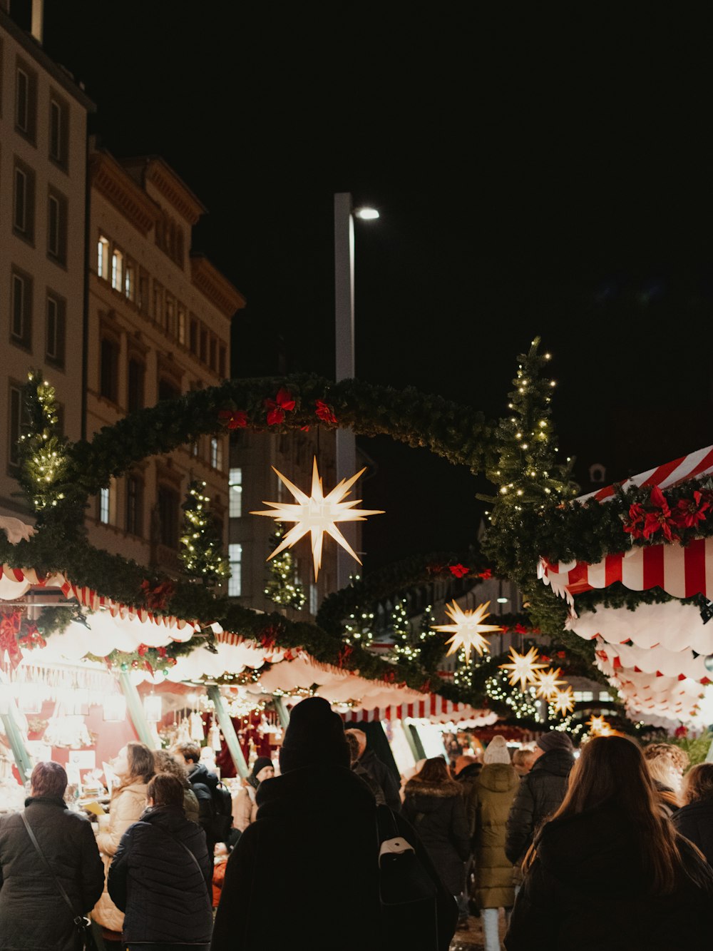 a crowd of people standing around a christmas market