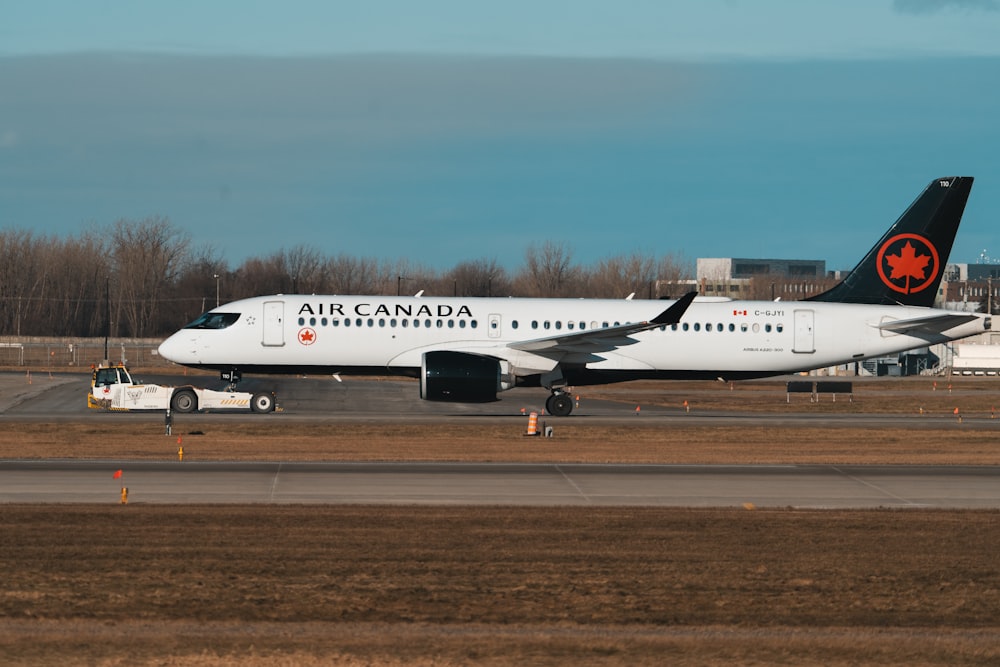 a large air canada jet sitting on top of an airport runway