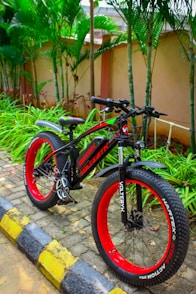 a red and black bike parked on the side of a road