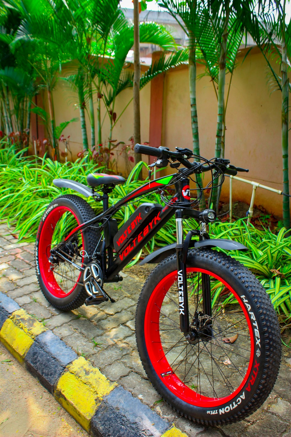 a red and black bike parked on the side of a road