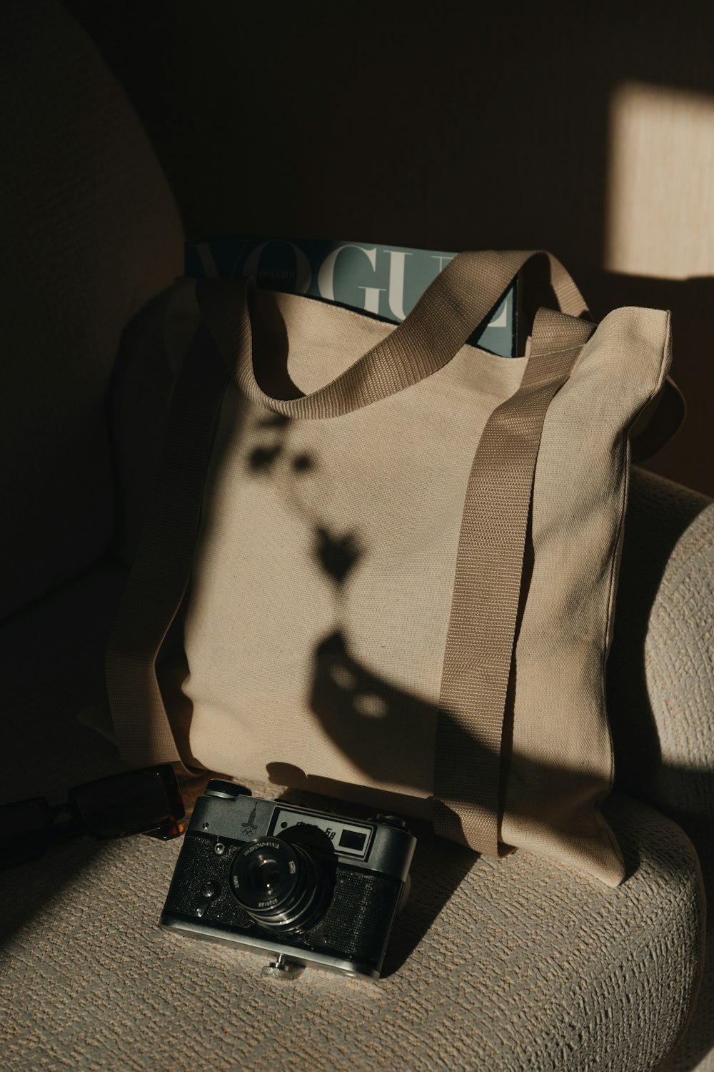 a camera and a tote bag sitting on a chair