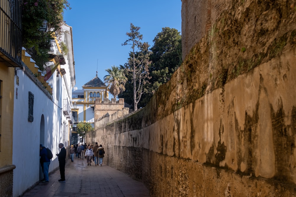 a group of people walking down a narrow street