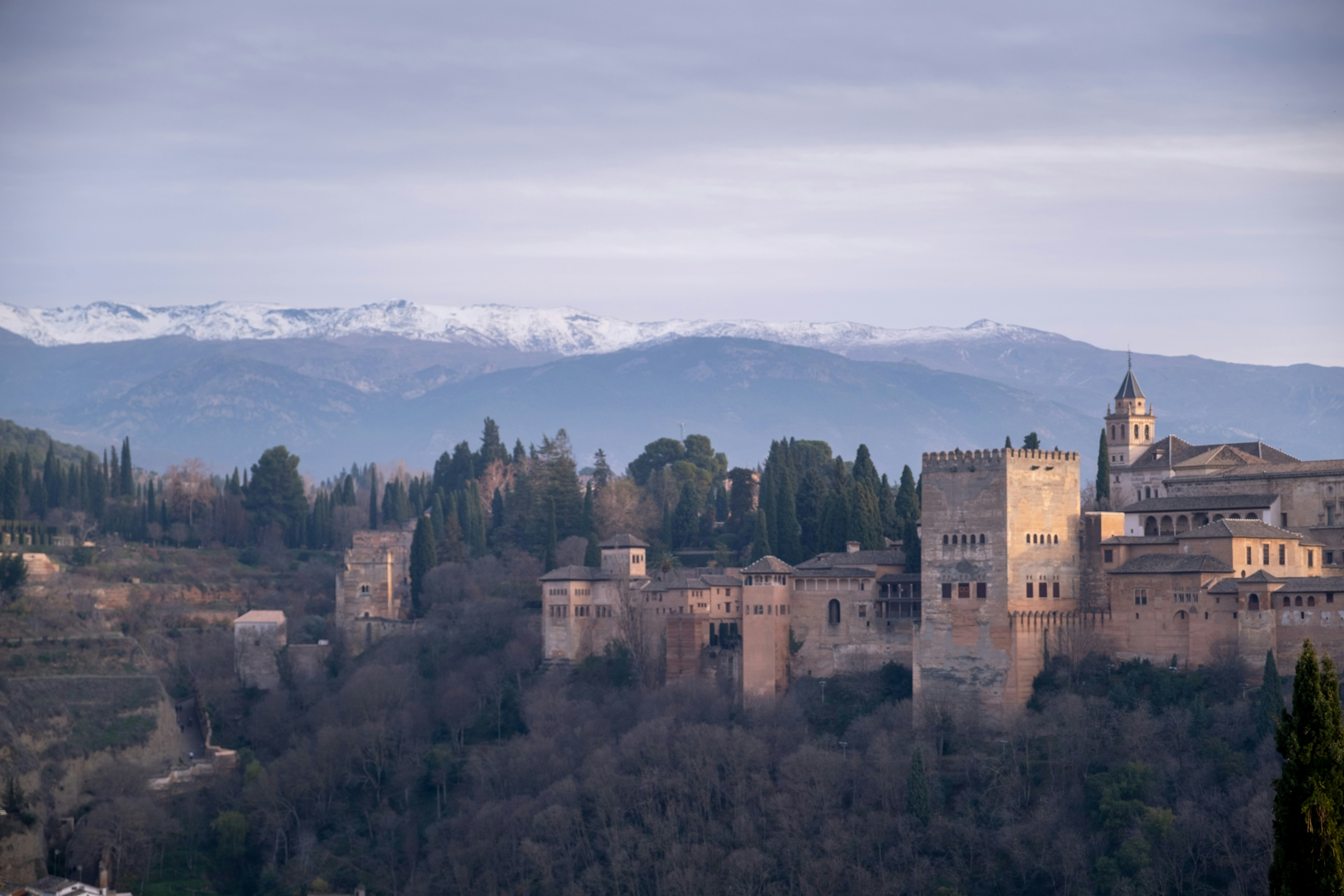 a castle with mountains in the background, 