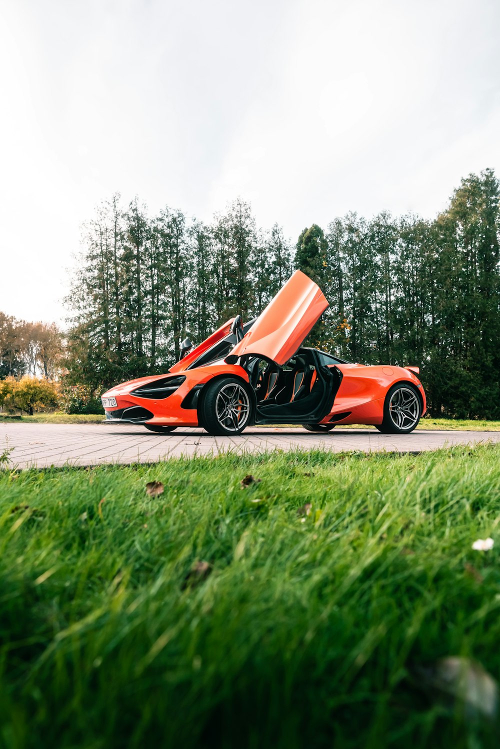 an orange sports car parked on the side of the road