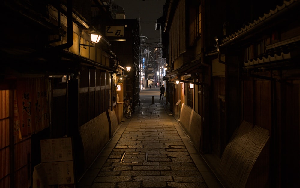 a dark alley with a person walking down it