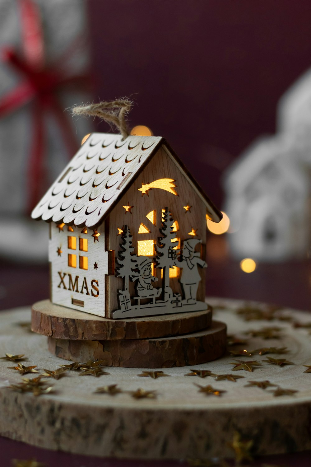 a small wooden house with a christmas scene on top of it