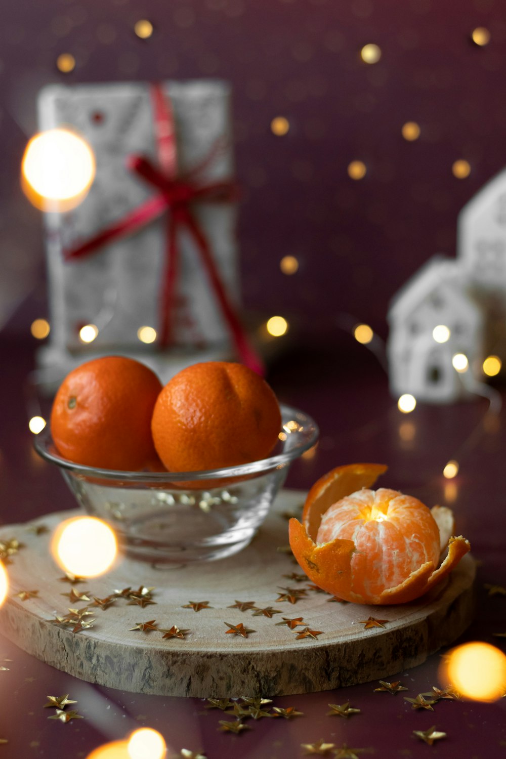 two oranges in a glass bowl on a table