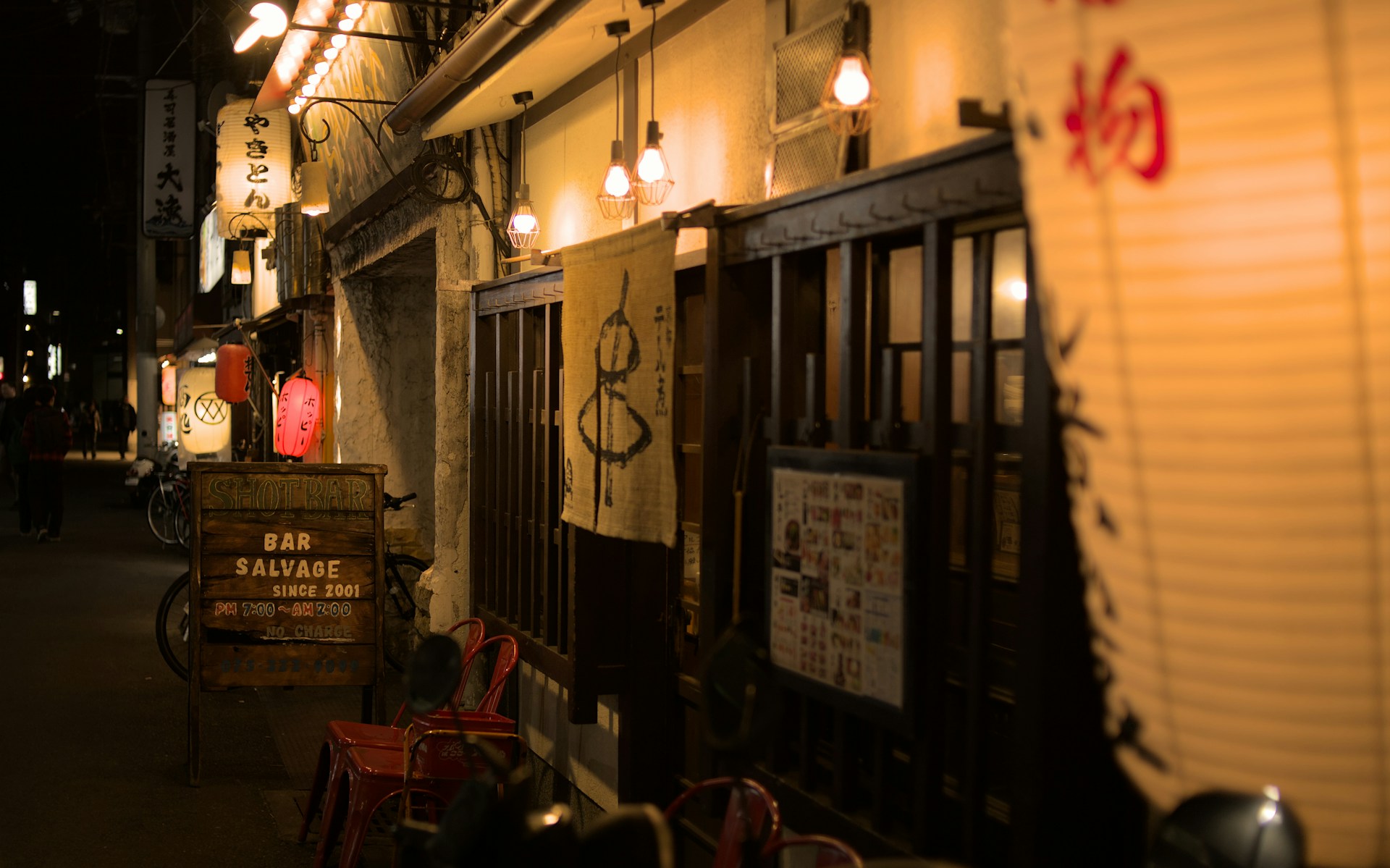 a dark alley with a sign and some lights