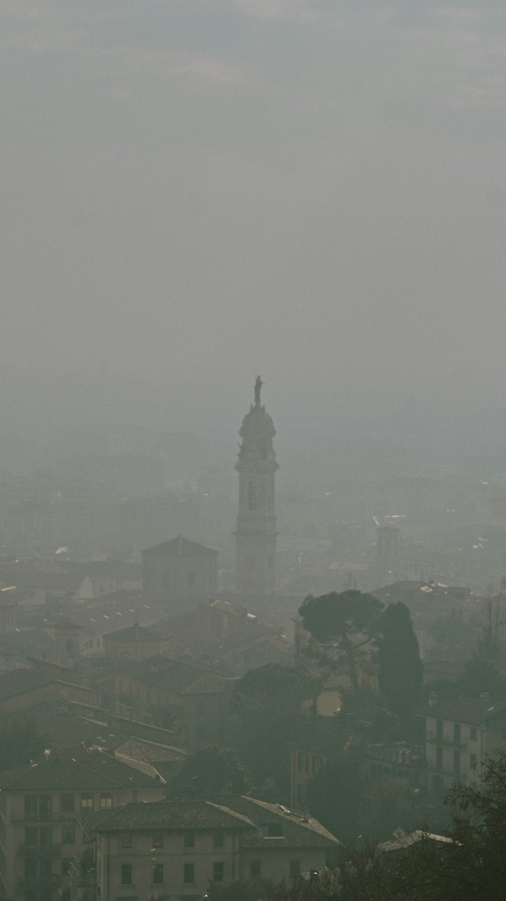 a foggy view of a city with a clock tower