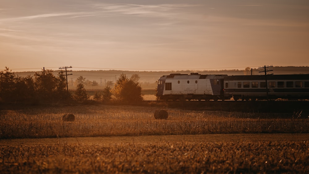 a train traveling through a rural countryside at sunset