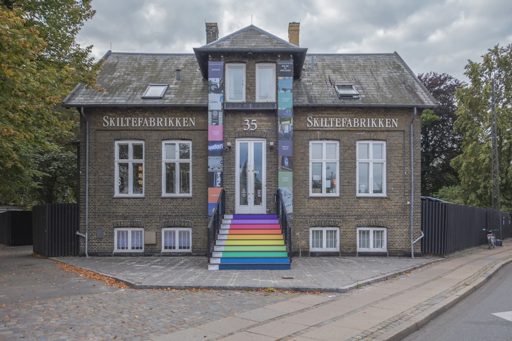 a building with a rainbow painted staircase in front of it