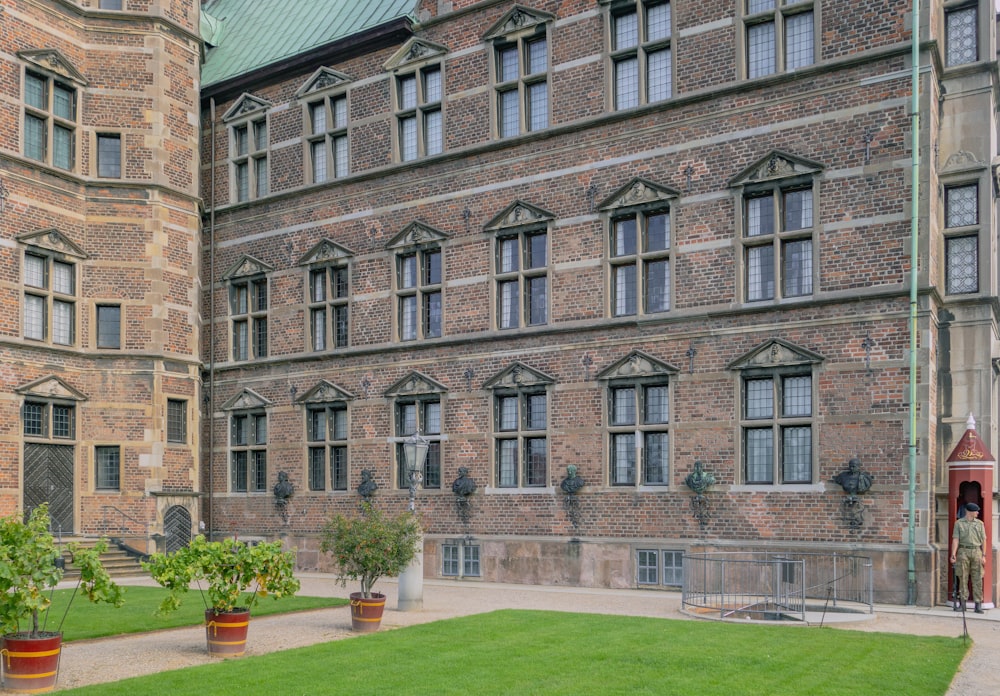 a large brick building with a green lawn in front of it