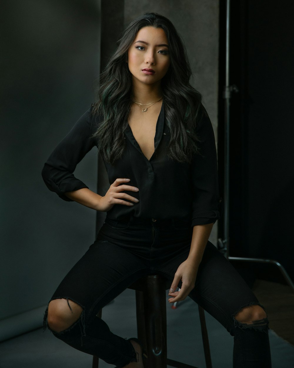 a woman sitting on a stool posing for a picture