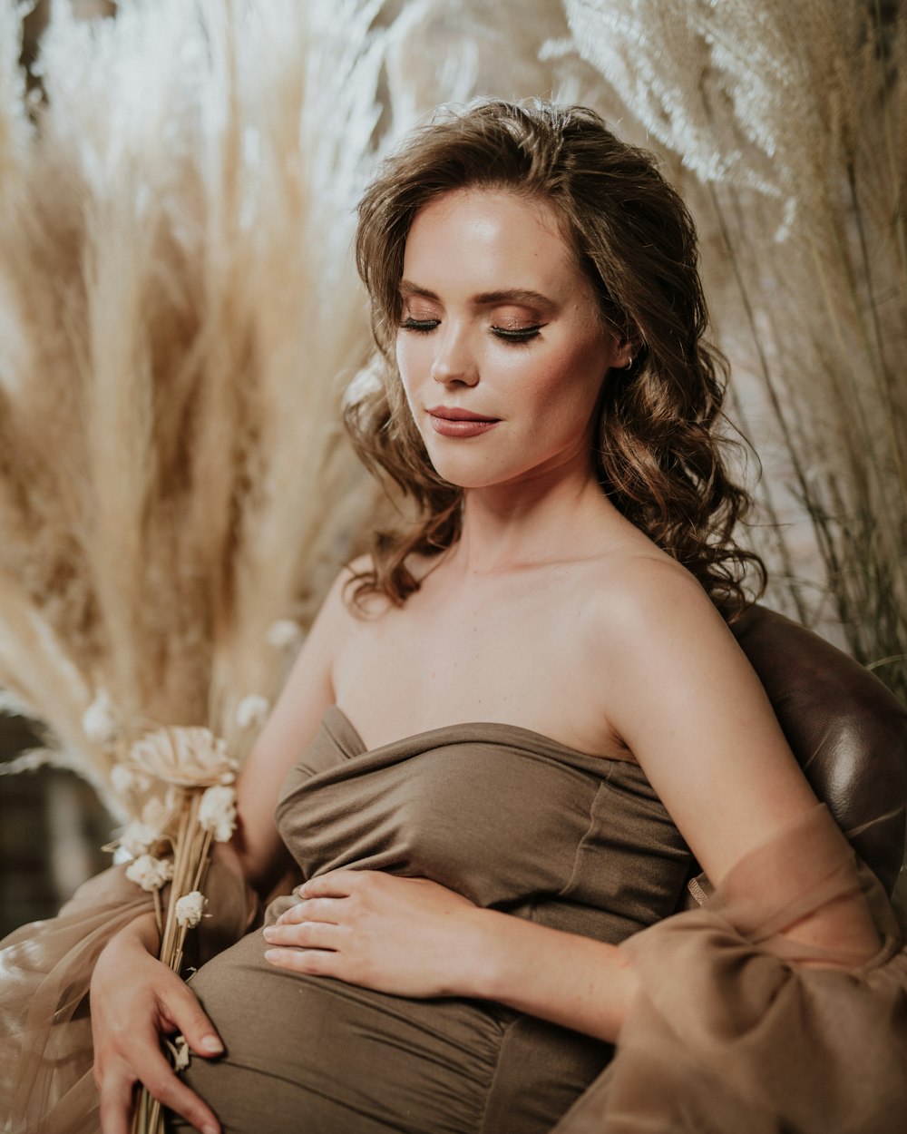 a pregnant woman sitting in a chair with her hands on her stomach