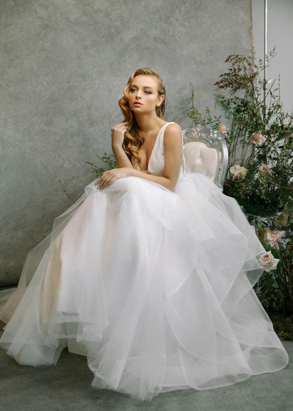 a woman in a white dress sitting on a chair