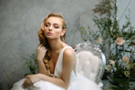 a woman in a white dress sitting on a chair
