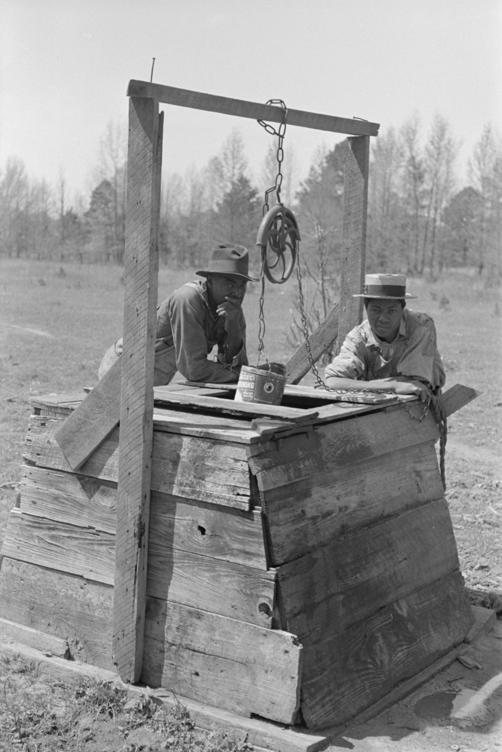 Negro farm owner and brother leaning on well top on their farm, near Jefferson, Texas