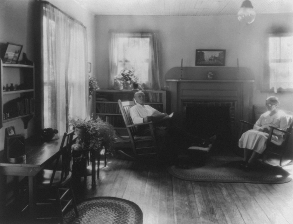 Man and woman in rockers by fireplace