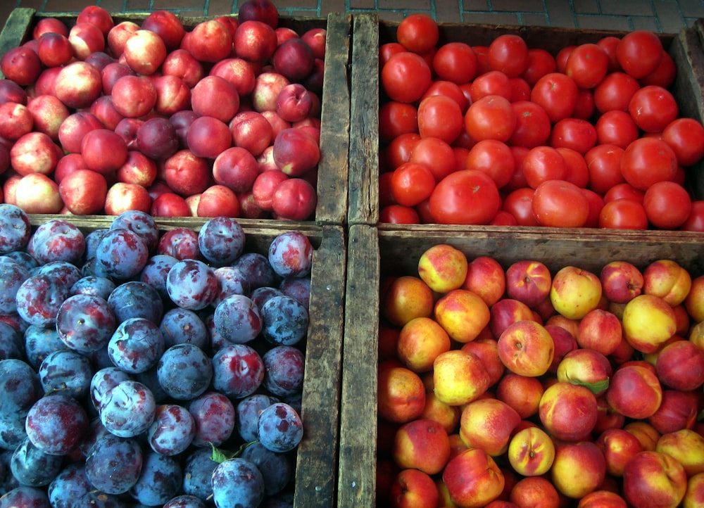 a variety of fruits in wooden boxes on display
