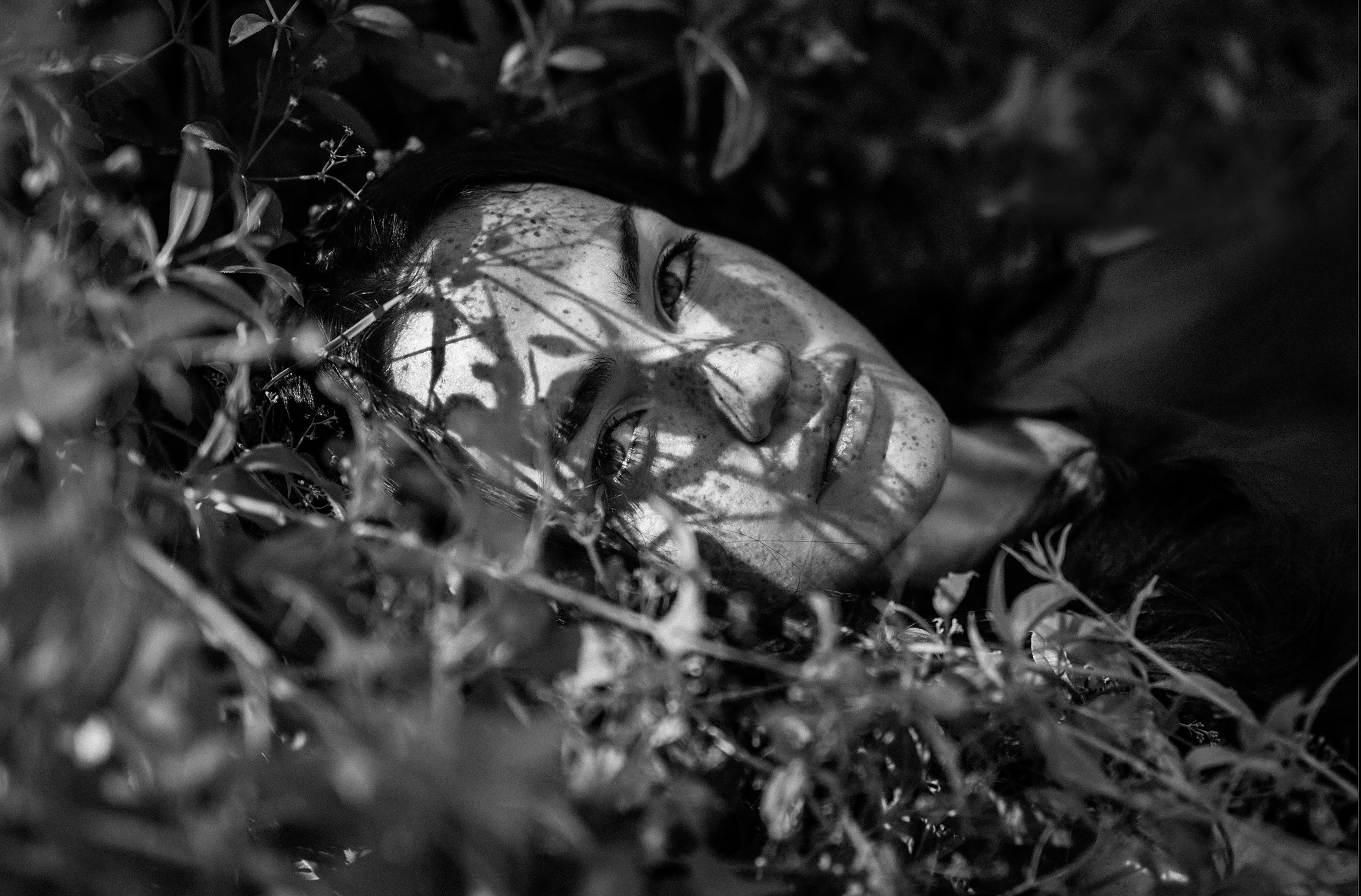 a black and white photo of a person laying in the grass