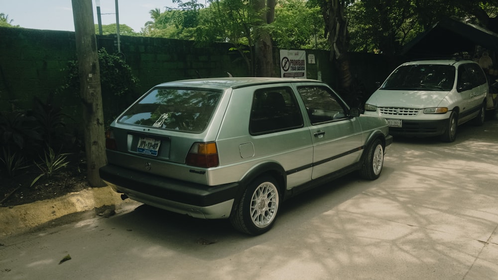 two cars parked next to each other in a driveway