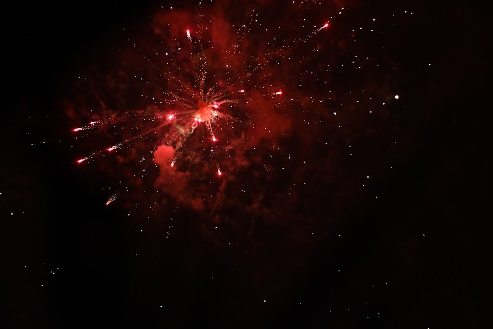 a red fireworks is lit up in the night sky