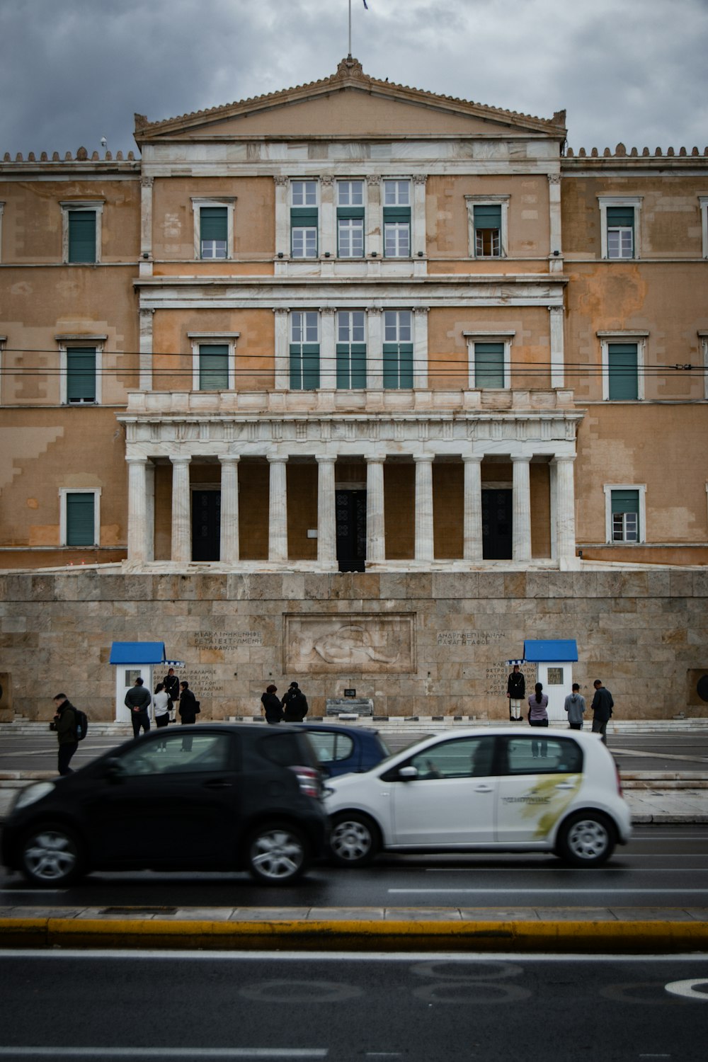 a white car driving past a tall building