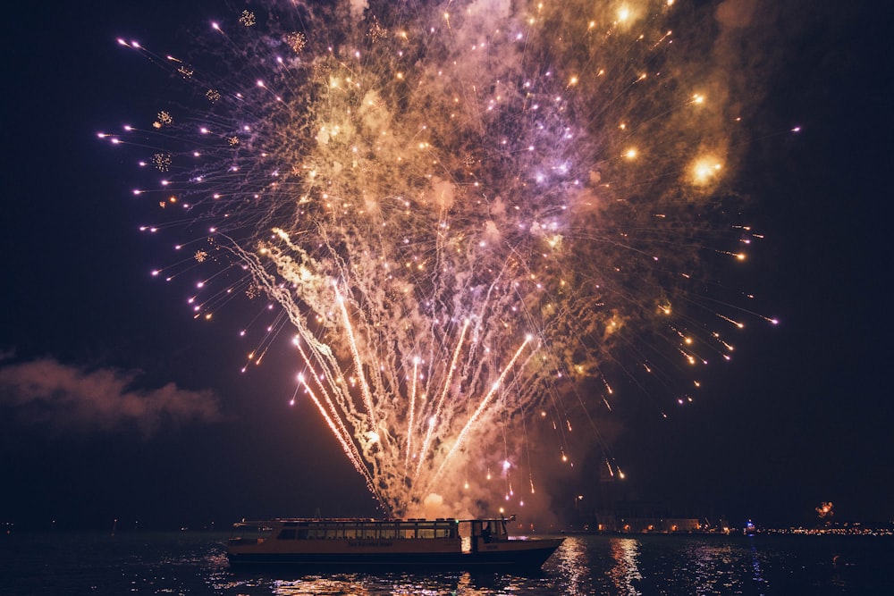 a boat in the water with a lot of fireworks in the sky