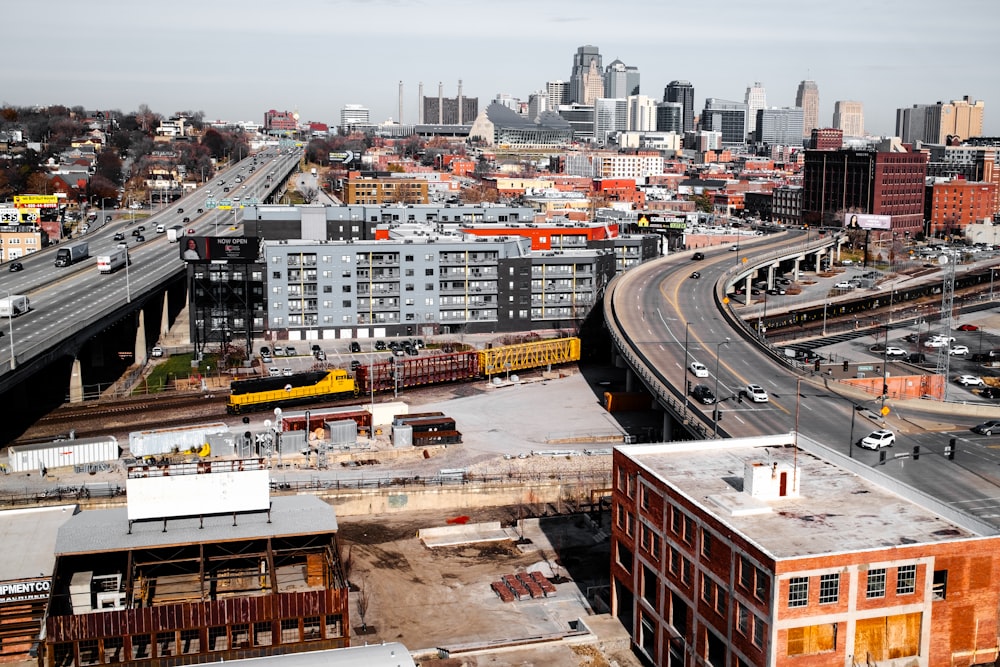 an aerial view of a city with a train on the tracks