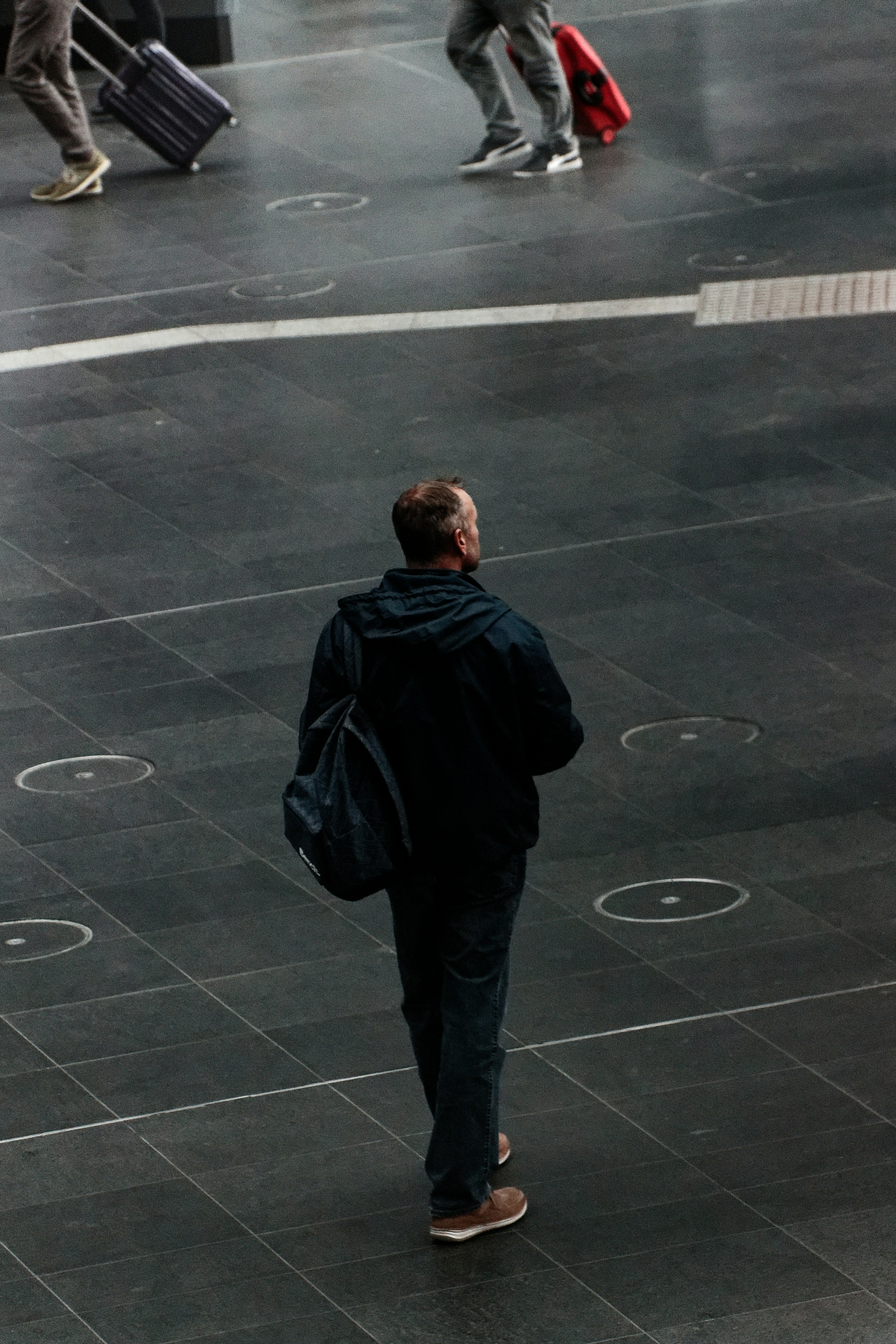 um homem caminhando por uma rua carregando uma sacola de bagagem
