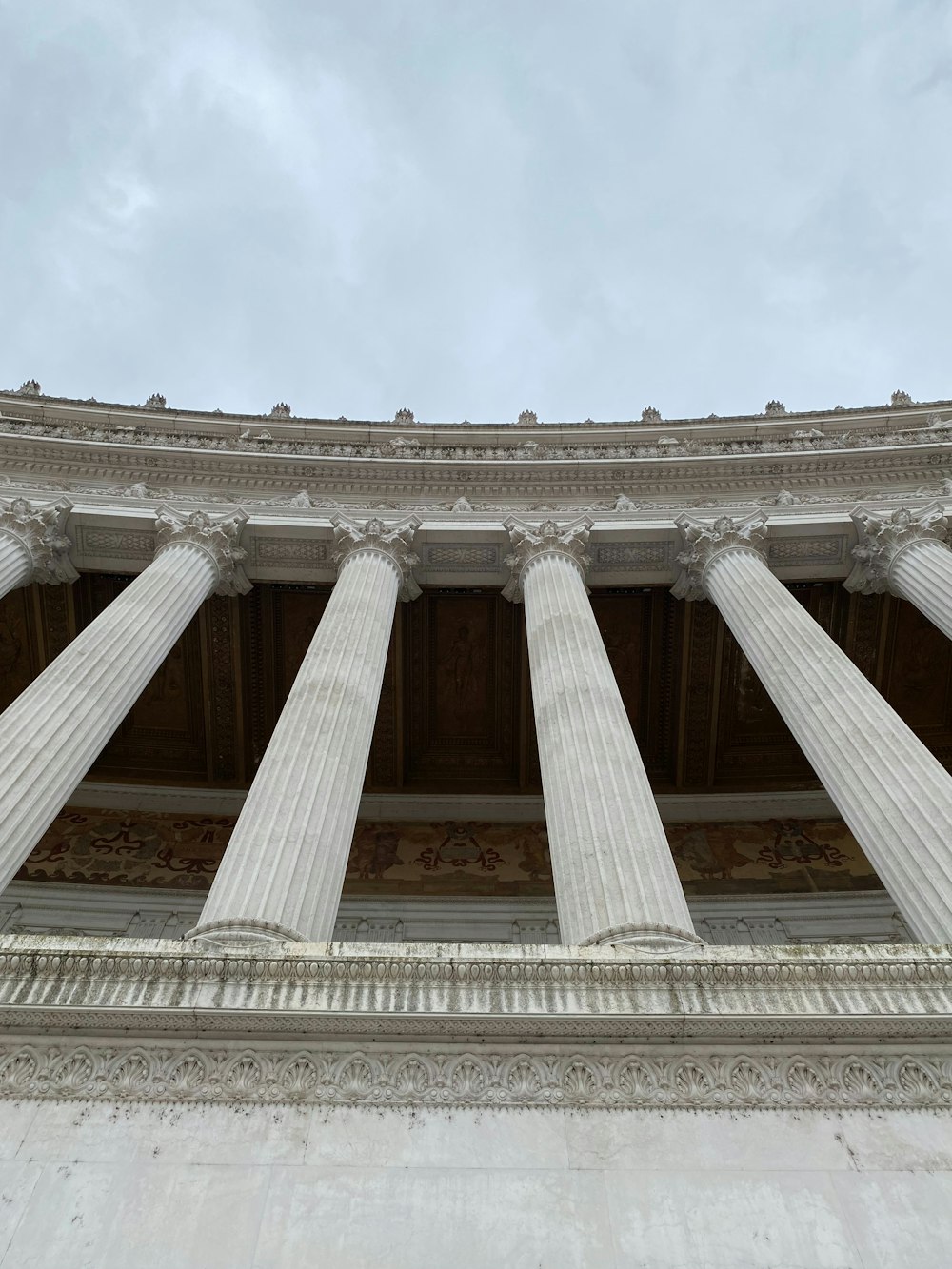 a tall white building with many columns on top of it