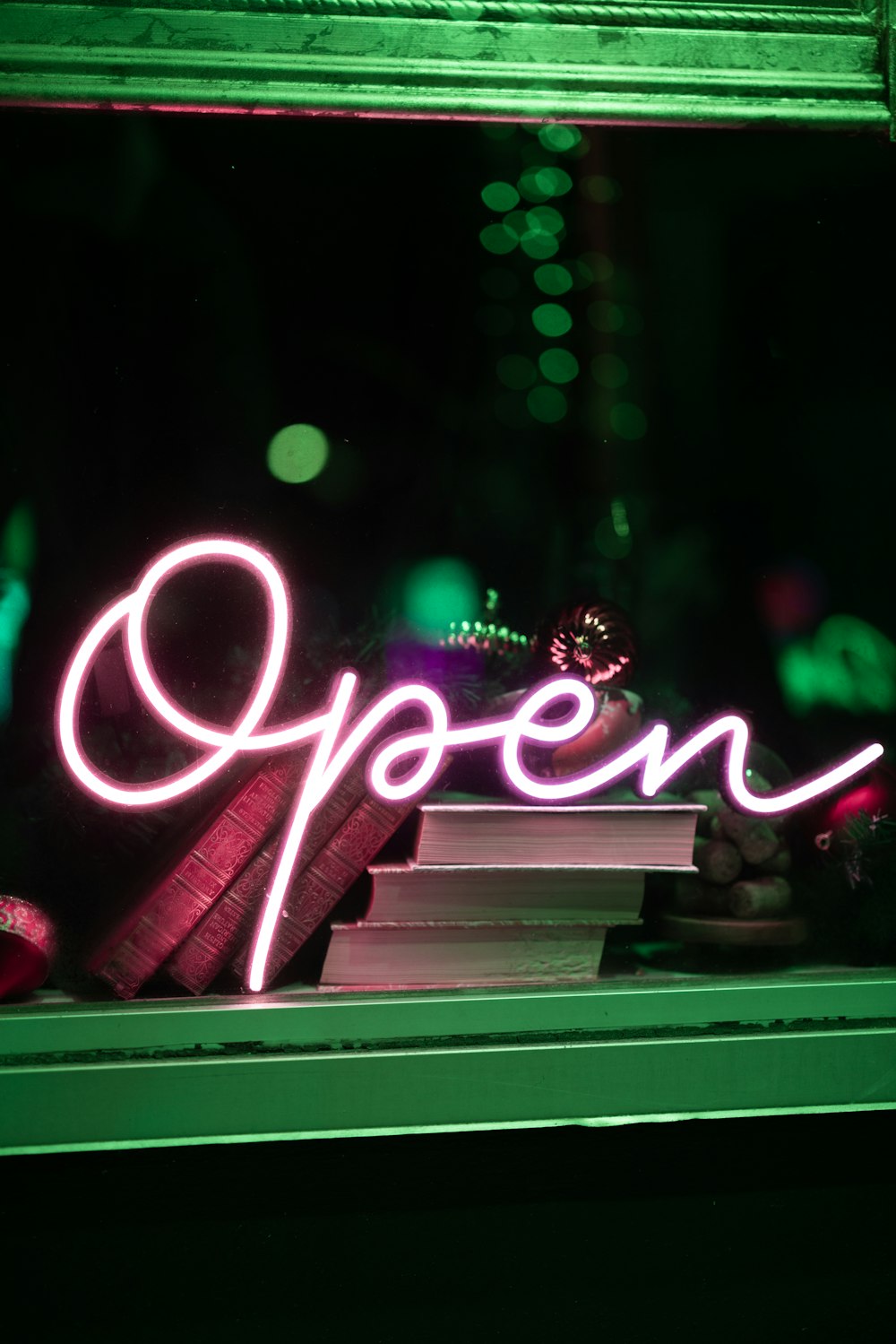 a neon sign that reads open in front of a window