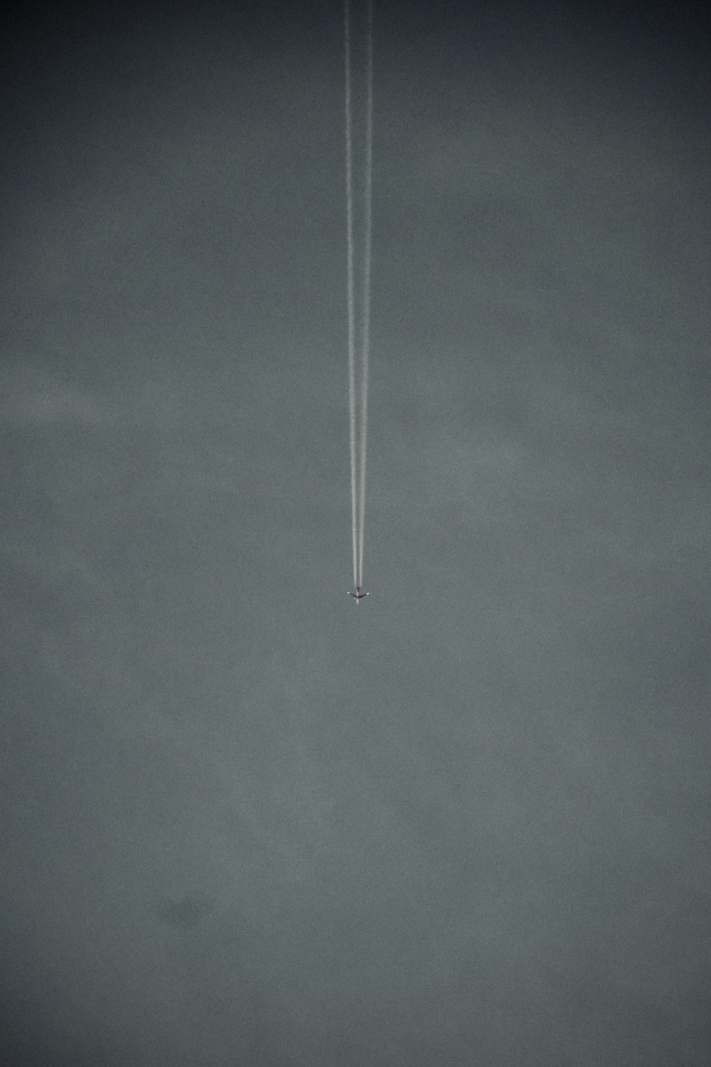 Ein Flugzeug fliegt mit einem Kondensstreifen am Himmel